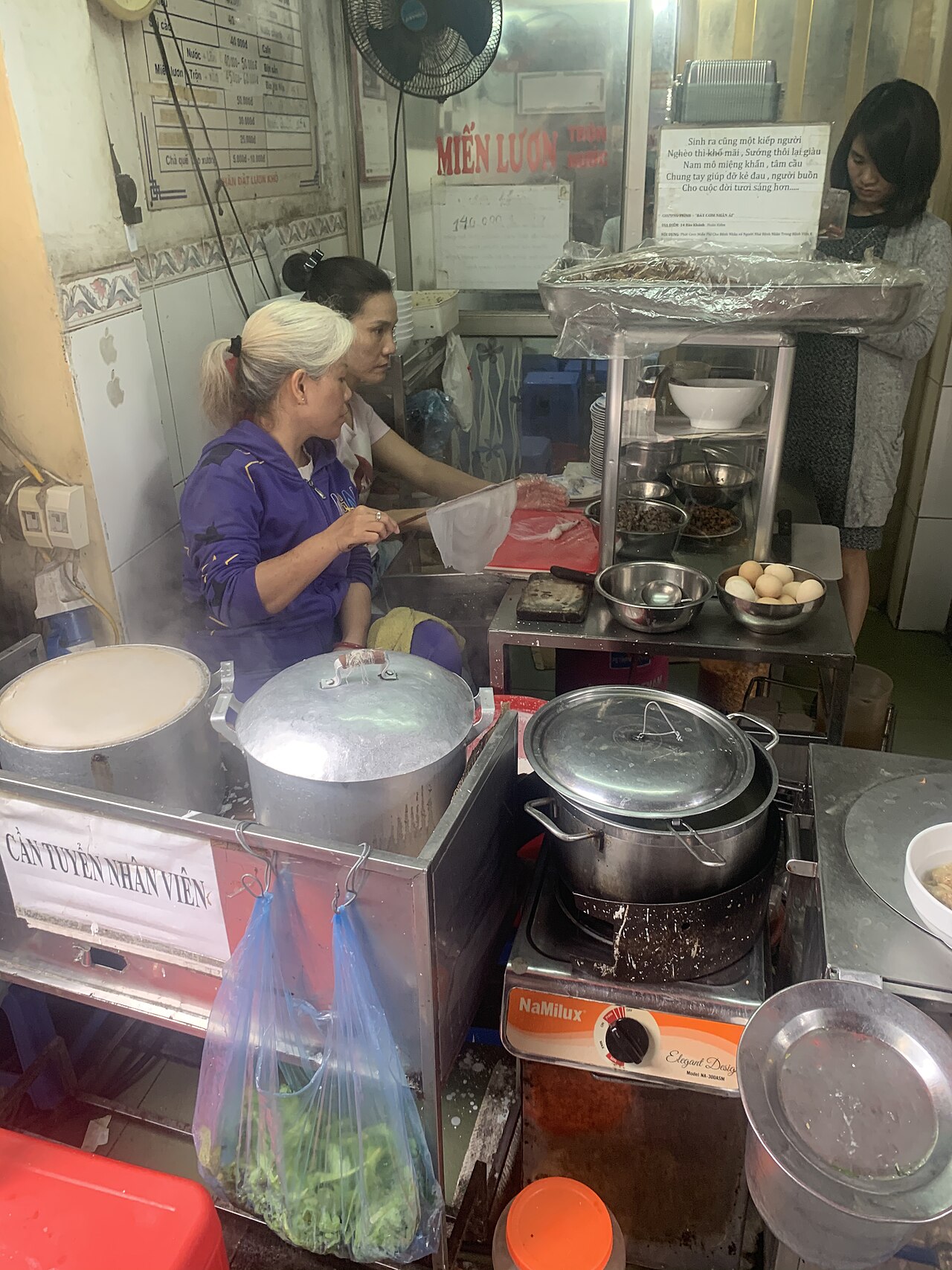 河內街頭小吃攤現場備料與烹調的畫面