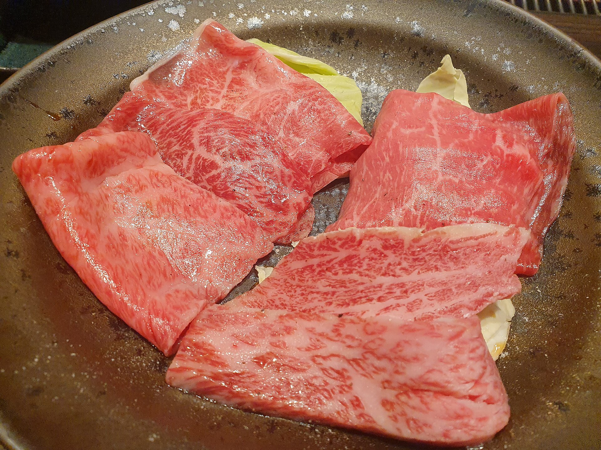 日式燒肉的烤網與肉片，一個人吃燒肉的份量要一輪一輪加